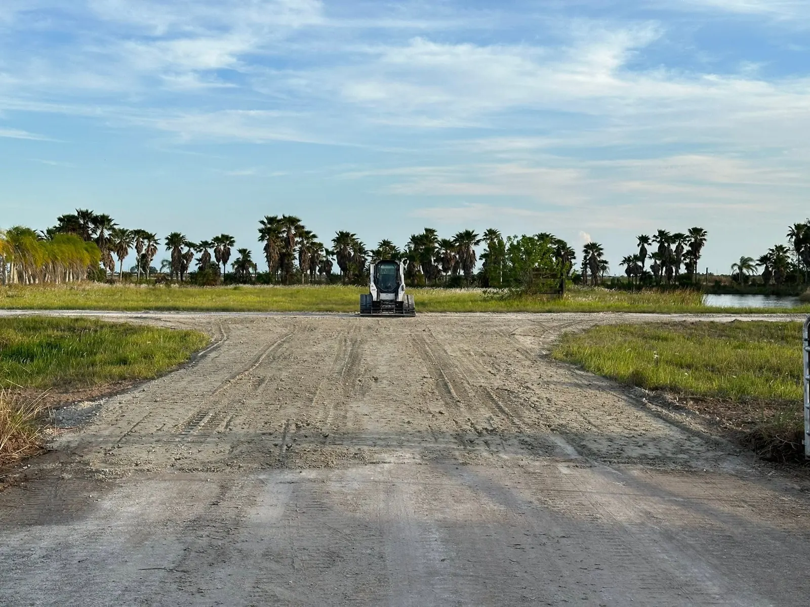 Wide graded driveway approach after site work