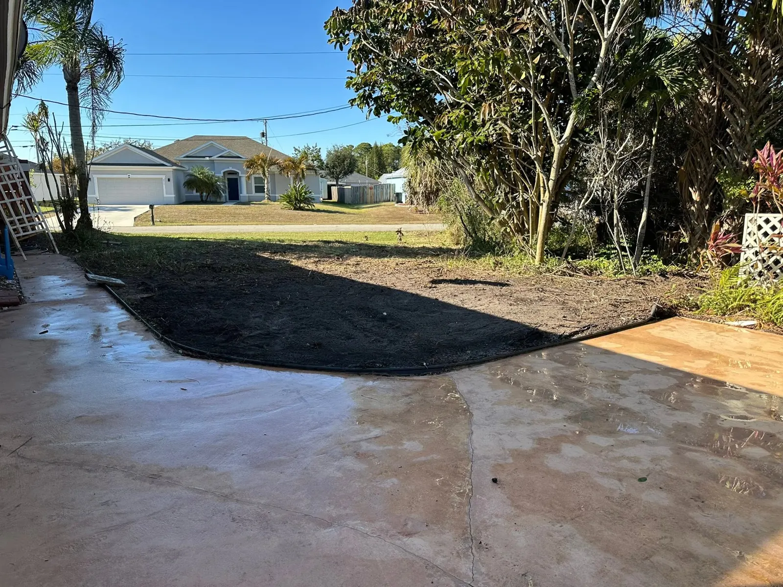 Backfilled work area beside the driveway and lawn